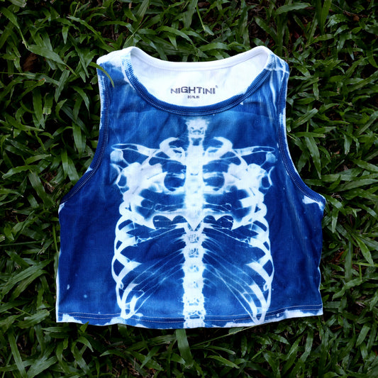 Blaues X-Ray Crop Top mit weißem Brustkorbmotiv, flach auf Gras fotografiert